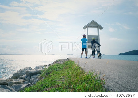 Couple cycling and Seascape of lifeguard tower 30768687