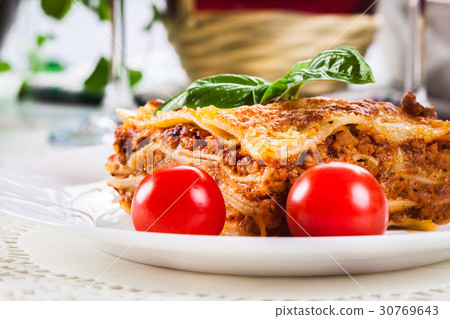 Piece of tasty hot lasagna with red wine.. 30769643