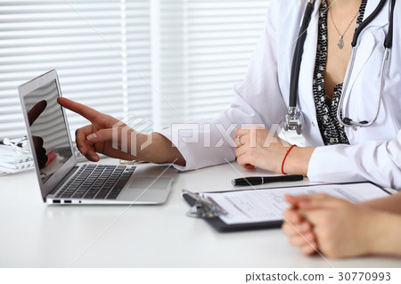 Close-up of a doctor and patient sitting at the 30770993