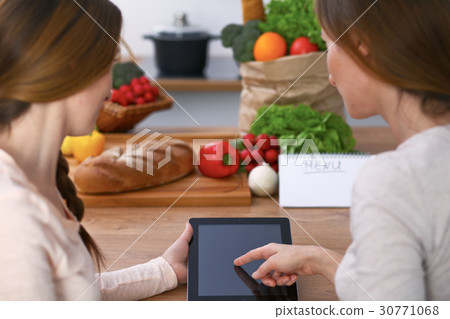 Human hands of two female persons using touchpad 30771068