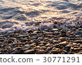 Wet shiny stones and small wave on the beach 30771291