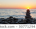 Cairn stones with sun on the beach on sundown 30771294