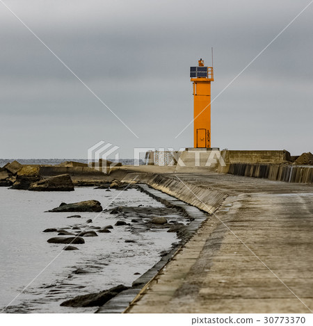 Breakwater dam with yellow lighthouse 30773370