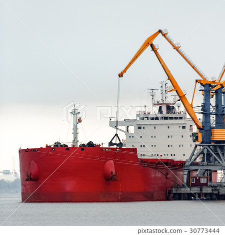 Large red cargo ship loading 30773444