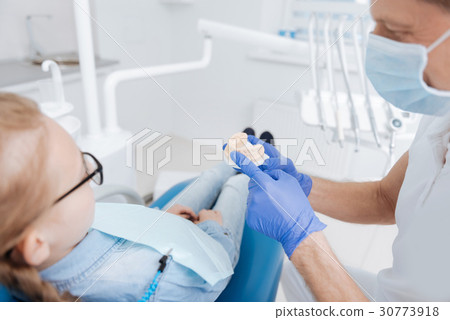 Caring nice dentist explaining the forthcoming Caring nice dentist explaining the forthcoming 30773918