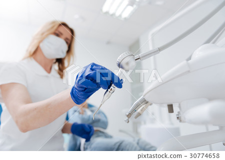 Concentrated excellent dentist picking the right 30774658