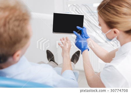 Savvy capable dentist using tablet for explanation Savvy capable dentist using tablet for explanation 30774708