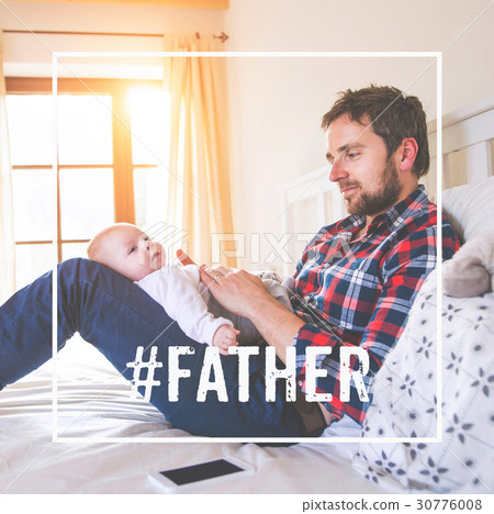 Father sitting on bed holding baby son. Fathers Father sitting on bed holding baby son. Fathers 30776008