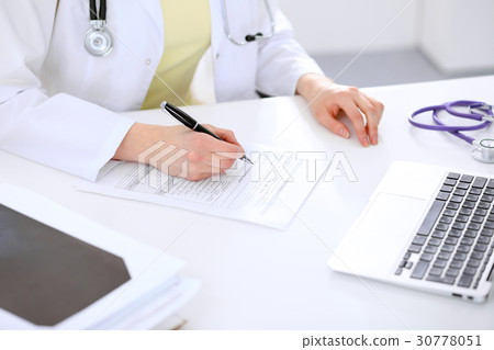 Close-up of a female doctor filling ou Close-up of a female doctor filling ou 30778051