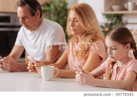 Involved ignorant family using smartphones at home 30778585