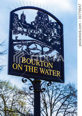 Bourton On The Water city sign against blue sky 30779047