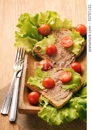 Chicken liver pate on the bread on wooden tray. Chicken liver pate on the bread on wooden tray. 30781181