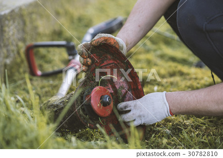 String trimmer cleaning after cutting the grass String trimmer cleaning after cutting the grass 30782810