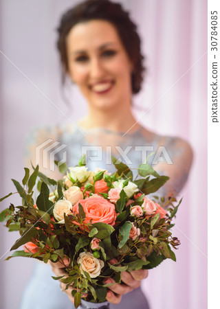 Beautiful woman in a plum dress holding a bouquet Beautiful woman in a plum dress holding a bouquet 30784085