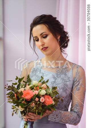 Beautiful woman in a plum dress posing with a 30784086
