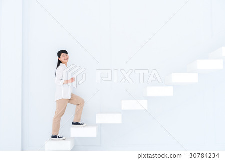 A young woman standing up the stairs 30784234