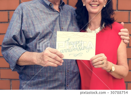 Couple holding a happy anniversary card Couple holding a happy anniversary card 30788754
