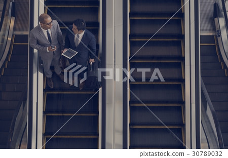 Business Men Talk Tablet Escalator 30789032
