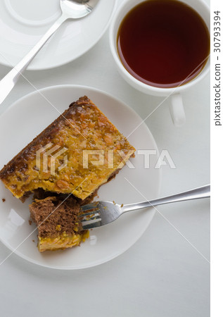 Caramel Peanut-Topped Brownie Cake and Cup of Tea. 30793394