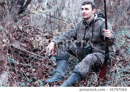 A man in camouflage and with a hunting rifle A man in camouflage and with a hunting rifle 30797068