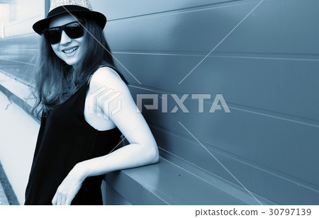 Cute girl hipster in a light hat and sunglasses 30797139