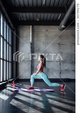 young woman doing yoga or pilates exercise. 30799279
