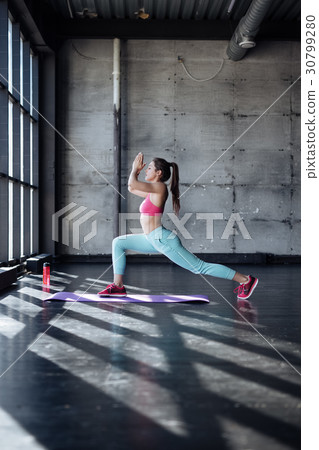 young woman doing yoga or pilates exercise. 30799280