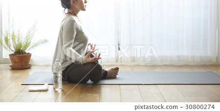 A woman is in padmasana pose of yoga postures. 30800274