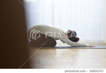 A photo of a woman doing cat flow pose of yoga. A photo of a woman doing cat flow pose of yoga. 30800345