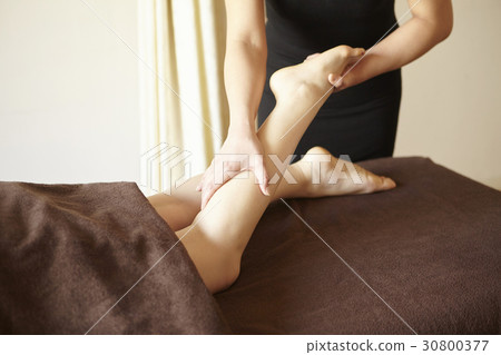 A photo of hands massaging legs of a woman in spa. 30800377