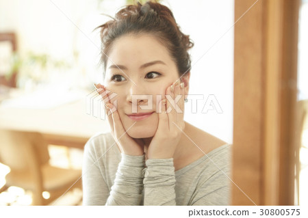 a portrait of a woman smiling and touching her face by two hands. a portrait of a woman smiling and touching her face by two hands. 30800575