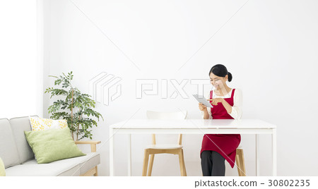 放鬆與片劑的一名微笑的婦女 放鬆與片劑的一名微笑的婦女 30802235