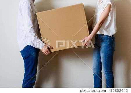 Male and female couple carrying cardboard boxes 30802643