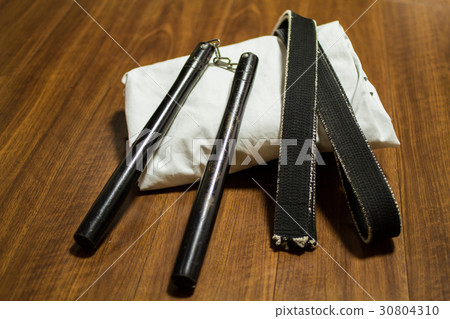 道場(空手道抵達)和道場地板上的黑帶,沖繩空手道“Nunchaku”的武器 道場(空手道抵達)和道場地板上的黑帶,沖繩空手道“Nunchaku”的武器 30804310