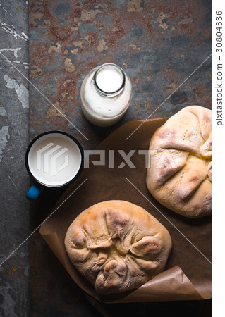 Ready-made khachapuri with cheese on parchment and 30804336