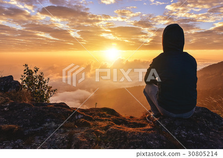 Lonely Man sitting on a mountain for watching  30805214