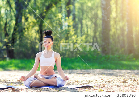 Young woman doing yoga exercises in the summer 30808386