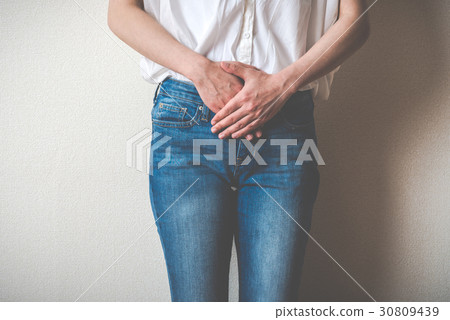 A woman holding the lower abdomen A woman holding the lower abdomen 30809439