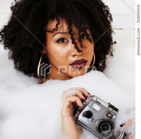 young afro-american teen girl laying in bath with 30809910