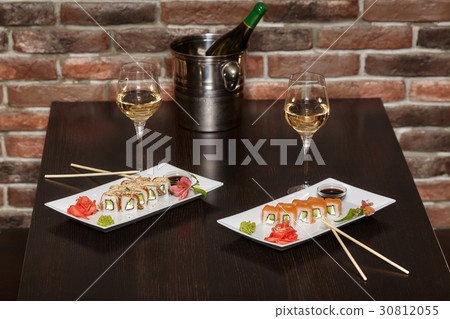 Two sets of sushi rolls with chopsticks and wine 30812055