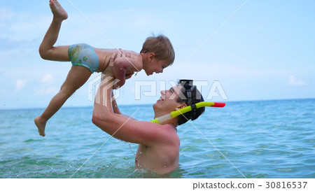 a guy with kid plays having fun in the sea a guy with kid plays having fun in the sea 30816537
