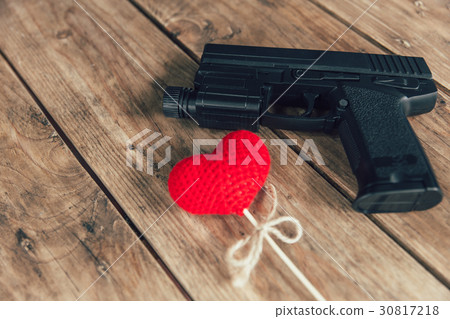 pistol gun and love red heart on wood background 30817218