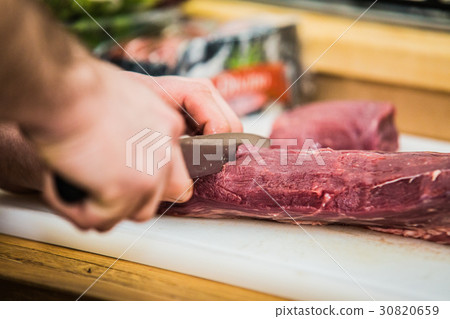 The chef in the kitchen prepares meat 30820659