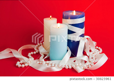 Three burning candles with a tape  30823961