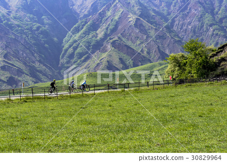 Cyclists going at the foot of Aso Cyclists going at the foot of Aso 30829964