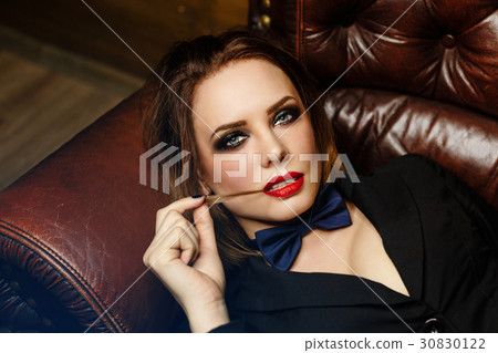 Femme fatale on leather couch Femme fatale on leather couch 30830122