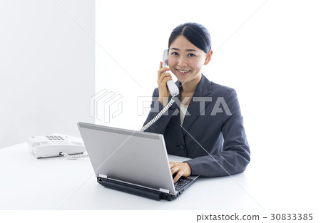 Business woman talking on a fixed telephone Business woman talking on a fixed telephone 30833385