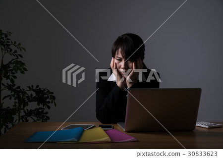 Businesswoman working overtime, holding a head Businesswoman working overtime, holding a head 30833623