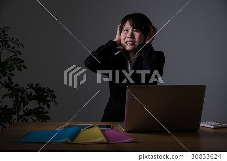 Businesswoman working overtime, holding a head Businesswoman working overtime, holding a head 30833624