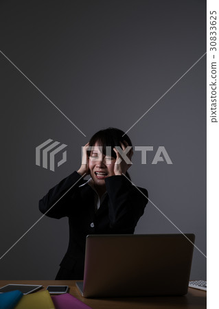 Businesswoman working overtime, holding a head Businesswoman working overtime, holding a head 30833625